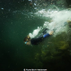 A boy is diving into the cold water of the west coast of ... by Rune Edvin Haldorsen 